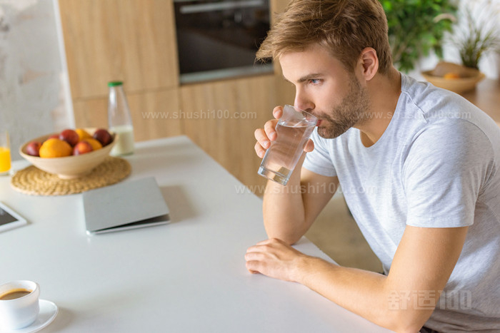 青年男子在餐桌边饮水的选择性焦点 _副本.jpg