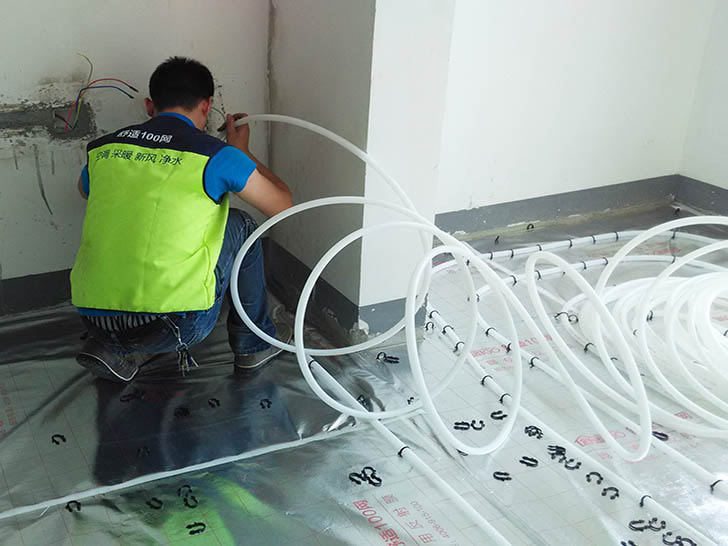 舒适100网施工人员在铺设地暖管