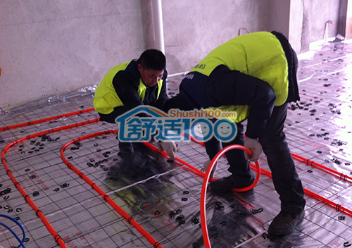铺设地暖管，舒适100网工程服务人员用卡钉固定地暖管